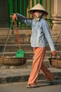 A woman is transporting goods in baskets in Hoi An (Vietnam) Royalty Free Stock Photo